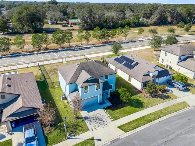 an aerial view of a house with a swimming pool and outdoor seating