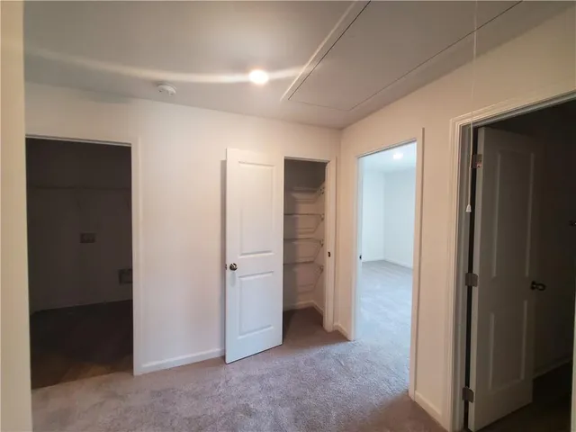 an empty room with closet and a bathroom