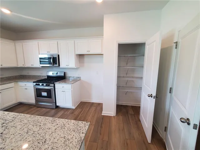 a kitchen with a refrigerator stove and wooden cabinets
