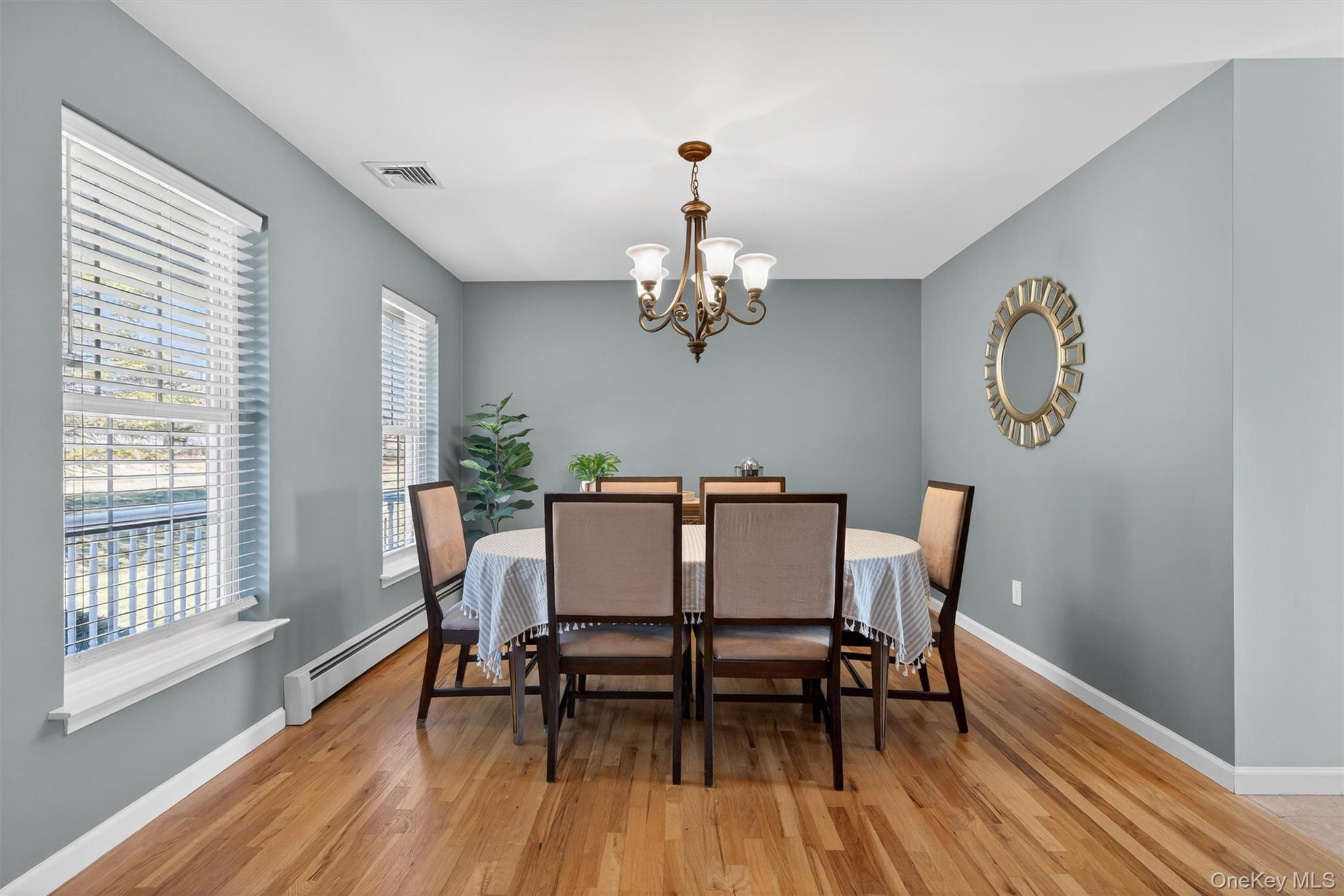 127 Egbertson Road Campbell Hall, NY 10916 - Photo 11 of 48 a dining room with wooden floor a chandelier a glass table and chairs