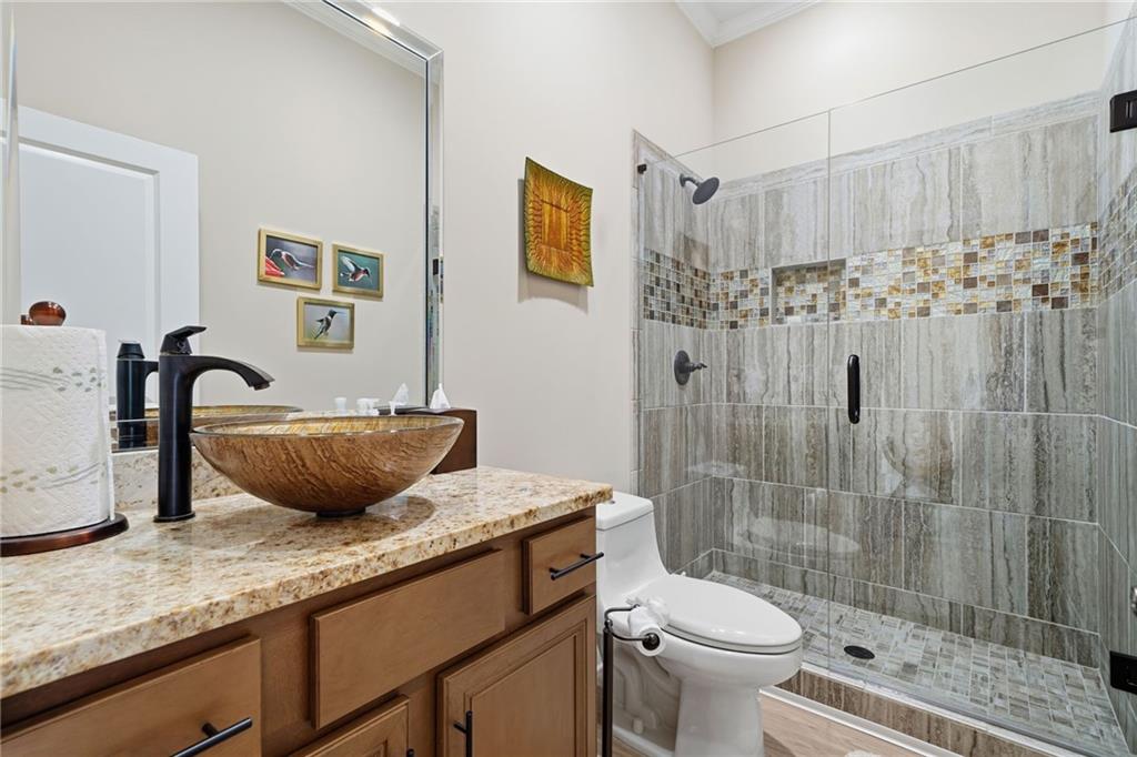 608 Red Leaf Way Canton, GA 30114 - Photo 38 of 43 a bathroom with a granite countertop sink a toilet a mirror and shower