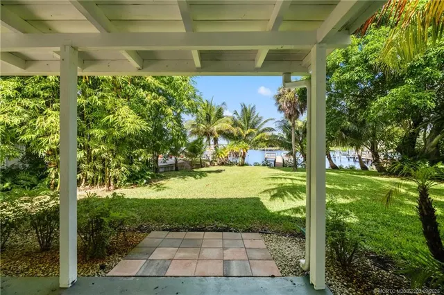 a balcony with table and chairs and potted plants