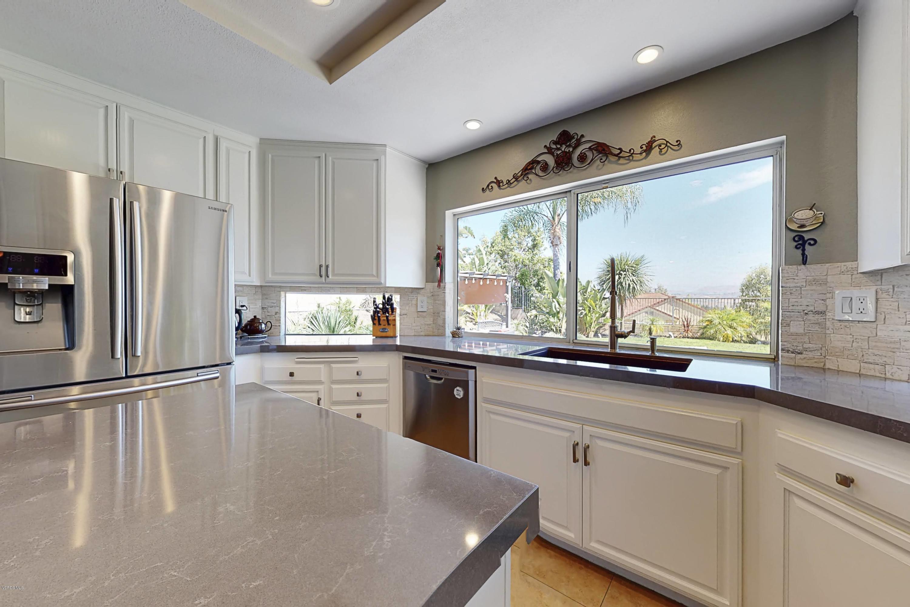 11577 Chestnut Ridge Street Moorpark, CA 93021 - Photo 13 of 58 a kitchen with granite countertop white cabinets and white appliances