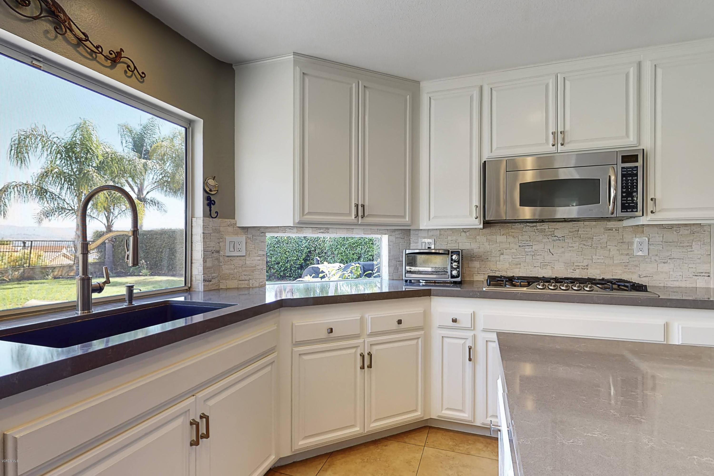 11577 Chestnut Ridge Street Moorpark, CA 93021 - Photo 14 of 58 a kitchen with stainless steel appliances granite countertop white cabinets and window