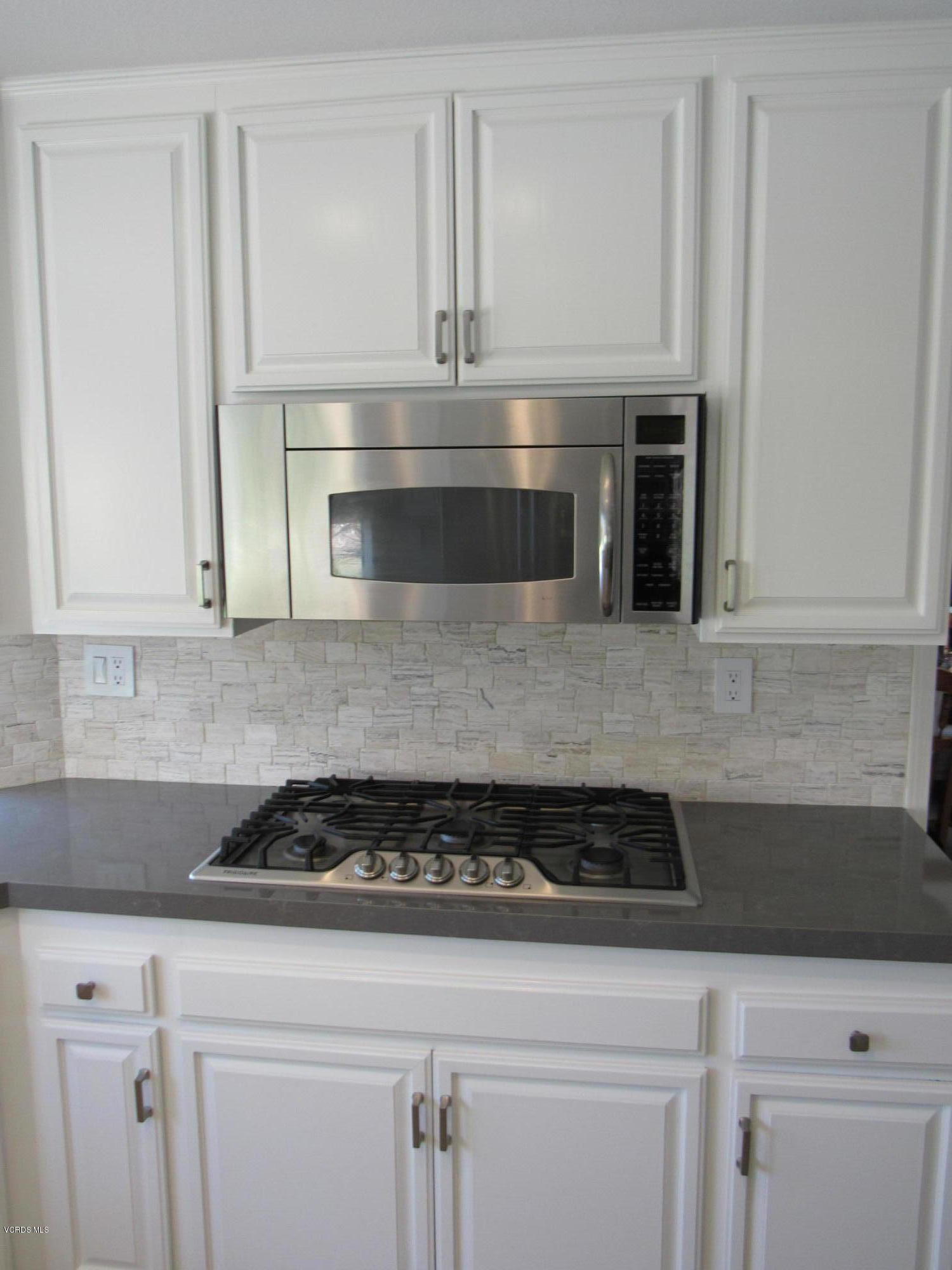 11577 Chestnut Ridge Street Moorpark, CA 93021 - Photo 15 of 58 a kitchen with granite countertop white cabinets and stainless steel appliances