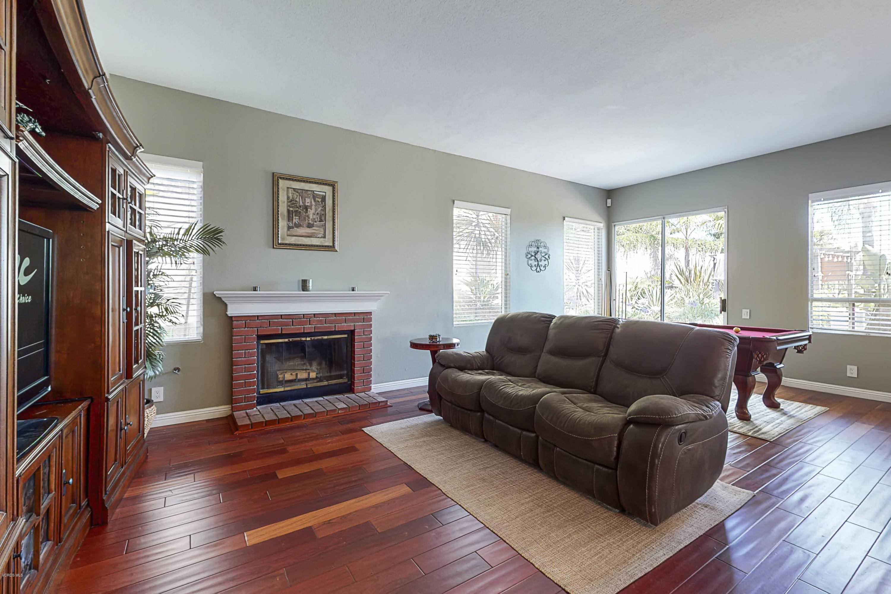 11577 Chestnut Ridge Street Moorpark, CA 93021 - Photo 20 of 58 a living room with furniture a flat screen tv and a fireplace