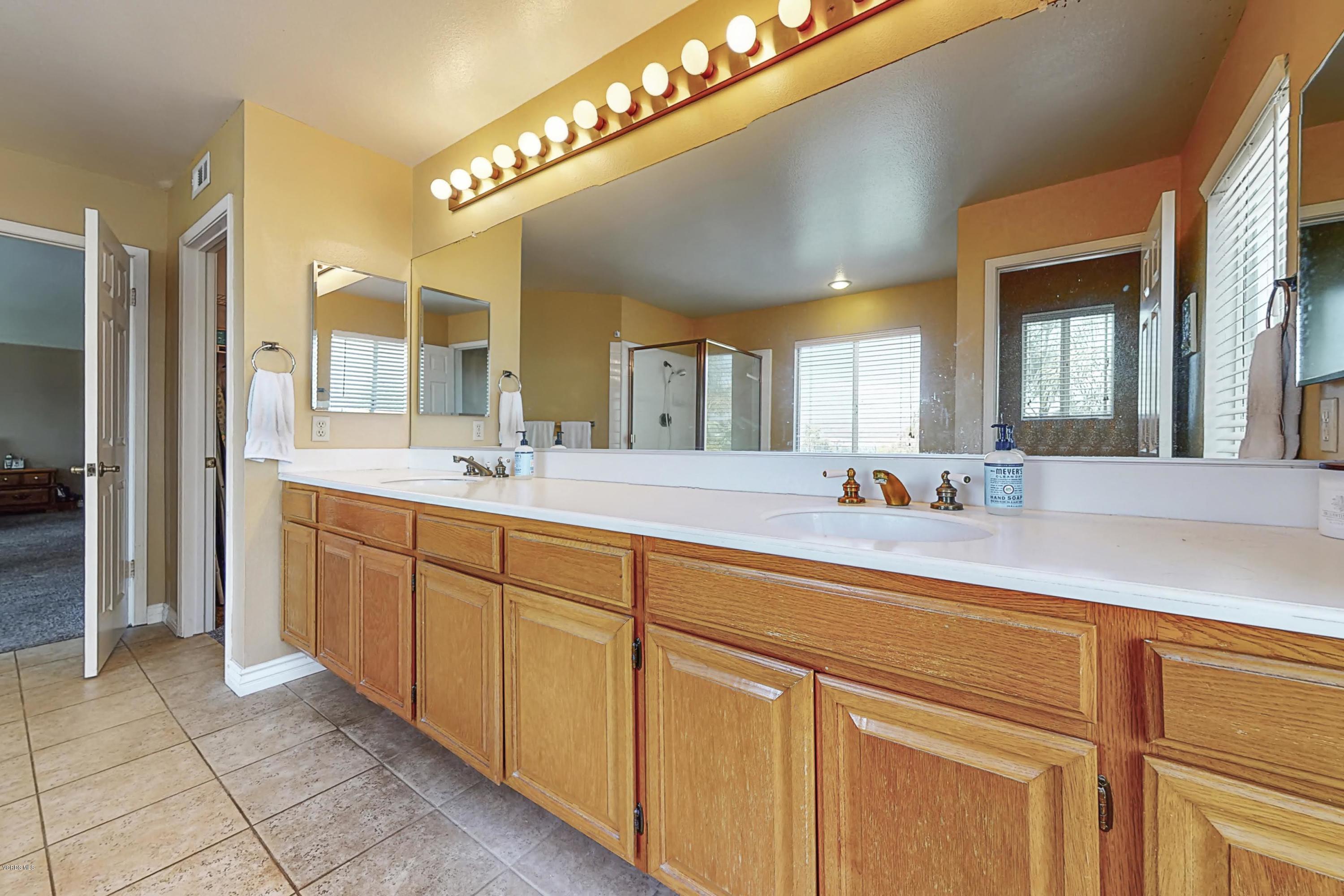 11577 Chestnut Ridge Street Moorpark, CA 93021 - Photo 37 of 58 a spacious bathroom with a double vanity sink and a mirror