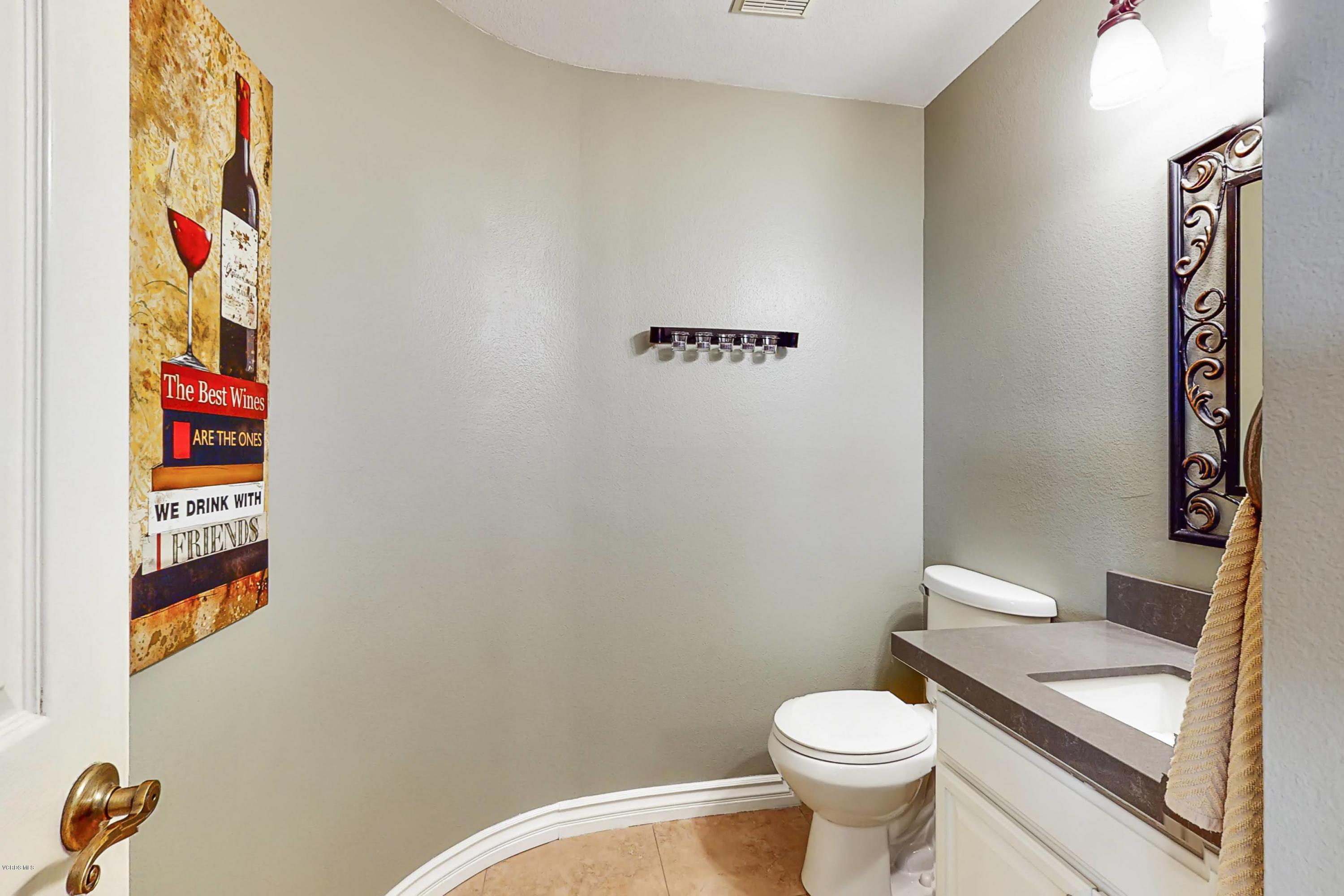 11577 Chestnut Ridge Street Moorpark, CA 93021 - Photo 7 of 58 a white toilet sitting next to a bathroom sink