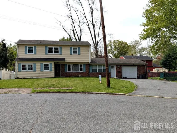 a front view of a house with a yard and trees