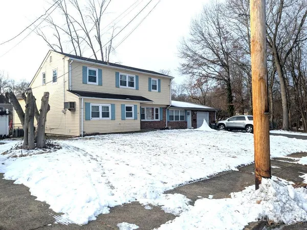 a front view of a house with a yard covered in snow