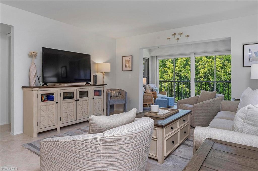 1001 Foxfire Lane, Unit 307 Naples, FL 34104 - Photo 8 of 23 a living room with furniture and a flat screen tv