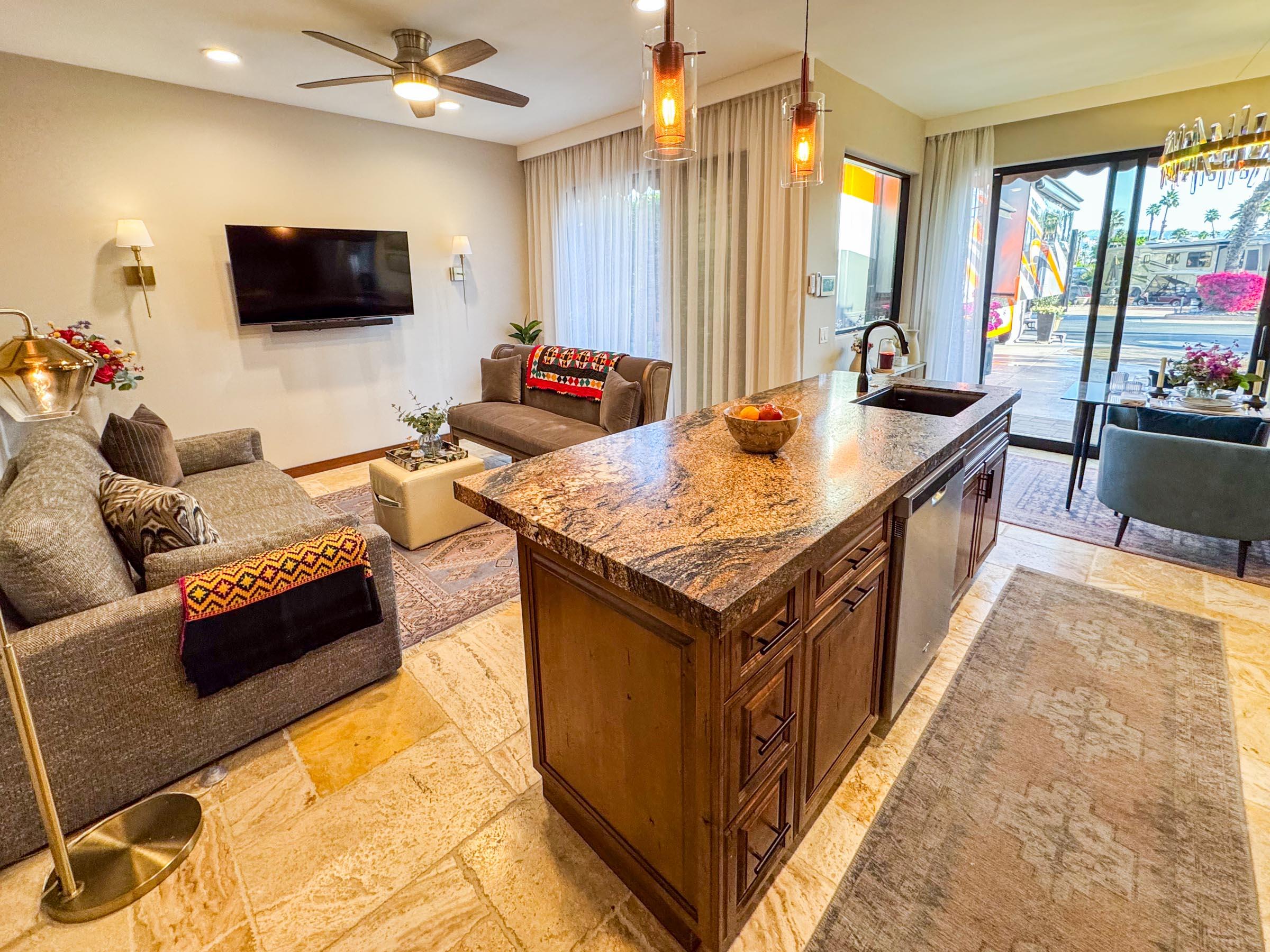 80394 Ave 48, Unit 156 Indio, CA 92201 - Photo 27 of 42 a living room with stainless steel appliances kitchen island granite countertop a sink and a flat screen tv