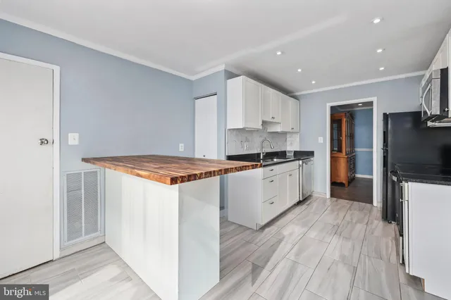 a kitchen with a refrigerator and a stove top oven