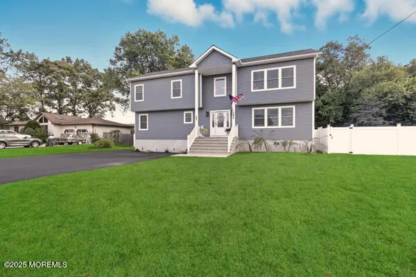 a front view of a house with a yard and trees