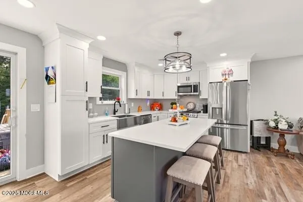 a view of a dining room and livingroom with furniture wooden floor a chandelier