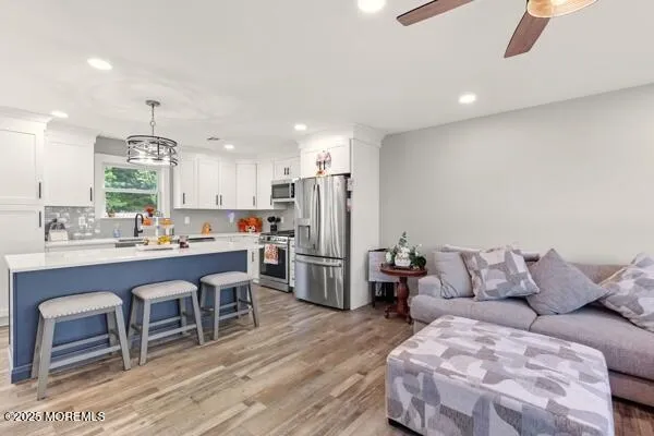 a living room with furniture a refrigerator and kitchen view