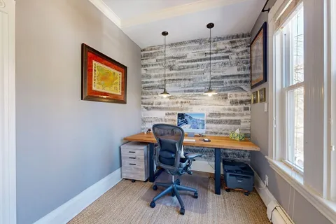 a view of a workspace with furniture and a window