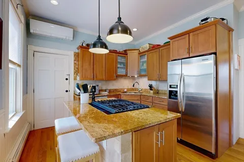 a kitchen with stainless steel appliances granite countertop a refrigerator a sink and a stove
