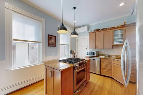 a kitchen with stainless steel appliances granite countertop a stove a sink and a refrigerator