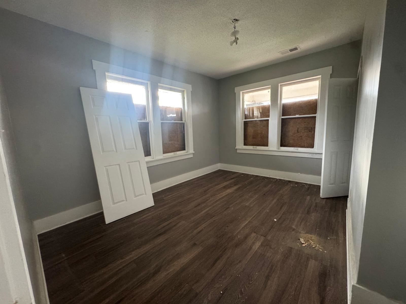 1134 Decatur Street Memphis, TN 38107 - Photo 9 of 12 an empty room with wooden floor and windows