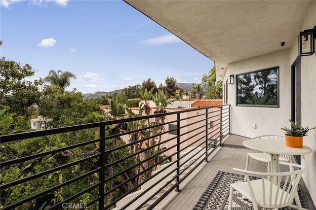 a view of a balcony with wooden floor and iron fence