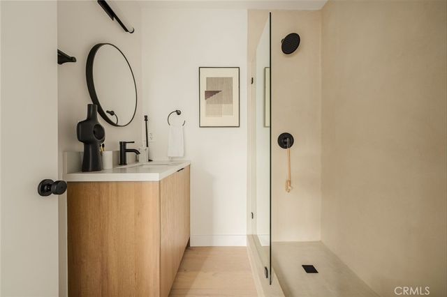 a bathroom with a sink a mirror a glass door shower and a mirror