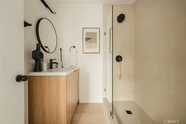 a bathroom with a sink a mirror a glass door shower and a mirror