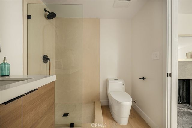 a bathroom with a granite countertop sink a toilet and shower