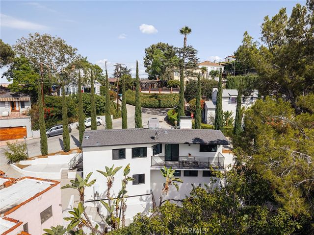 a front view of a house with a yard and fountain in middle of the road