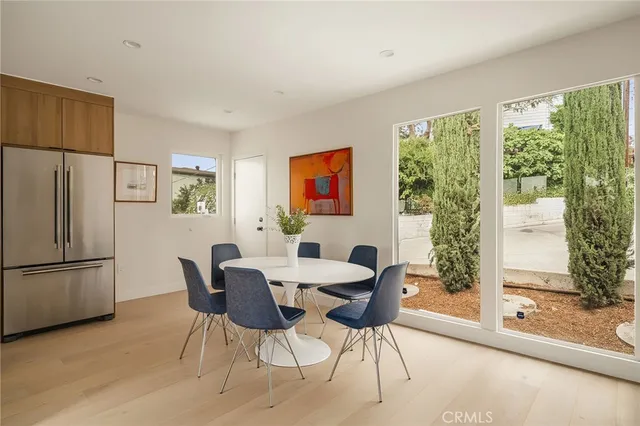 a view of a dining room with furniture large window and refrigerator