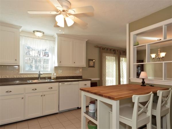 93 Allen Road Billerica, MA 01821 - Photo 4 of 25 a kitchen with a stove a sink a dining table and chairs