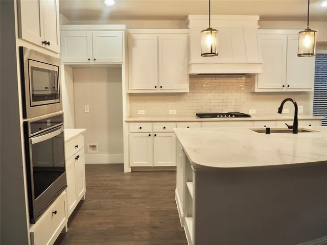 a kitchen with stainless steel appliances a refrigerator sink and cabinets