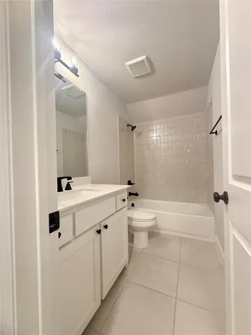 a bathroom with a toilet a sink a mirror a bathtub and vanity