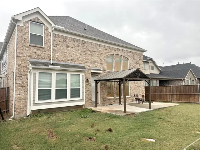 a view of a house with a backyard and a patio