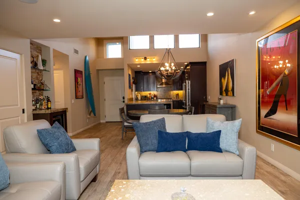a living room with furniture and a large mirror with wooden floor