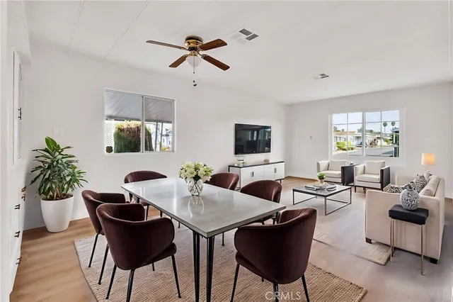 a view of a livingroom and dining room with furniture window and wooden floor