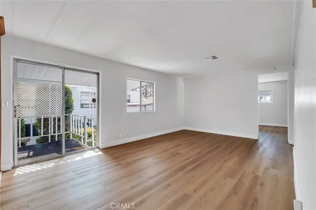 an empty room with a wooden floor and windows