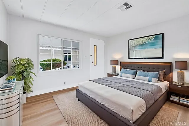 a bedroom with bed and a potted plant