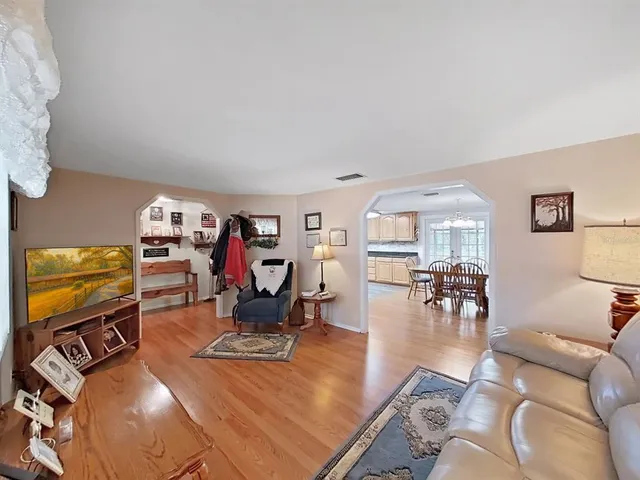 a kitchen with stainless steel appliances granite countertop a refrigerator a sink dishwasher a stove and white countertops with wooden floor