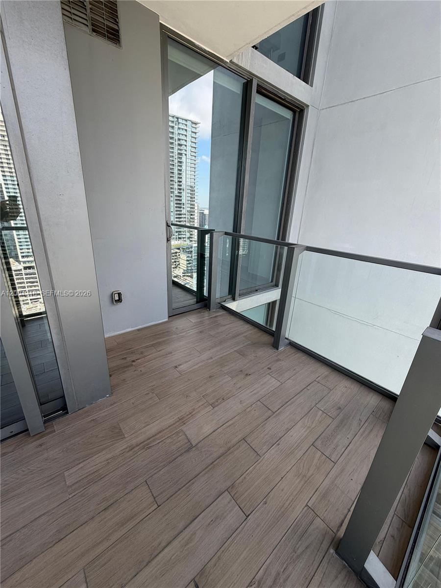 68 Southeast 6th Street, Unit 2506 Miami, FL 33131 - Photo 14 of 16 an empty room with wooden floor and a window
