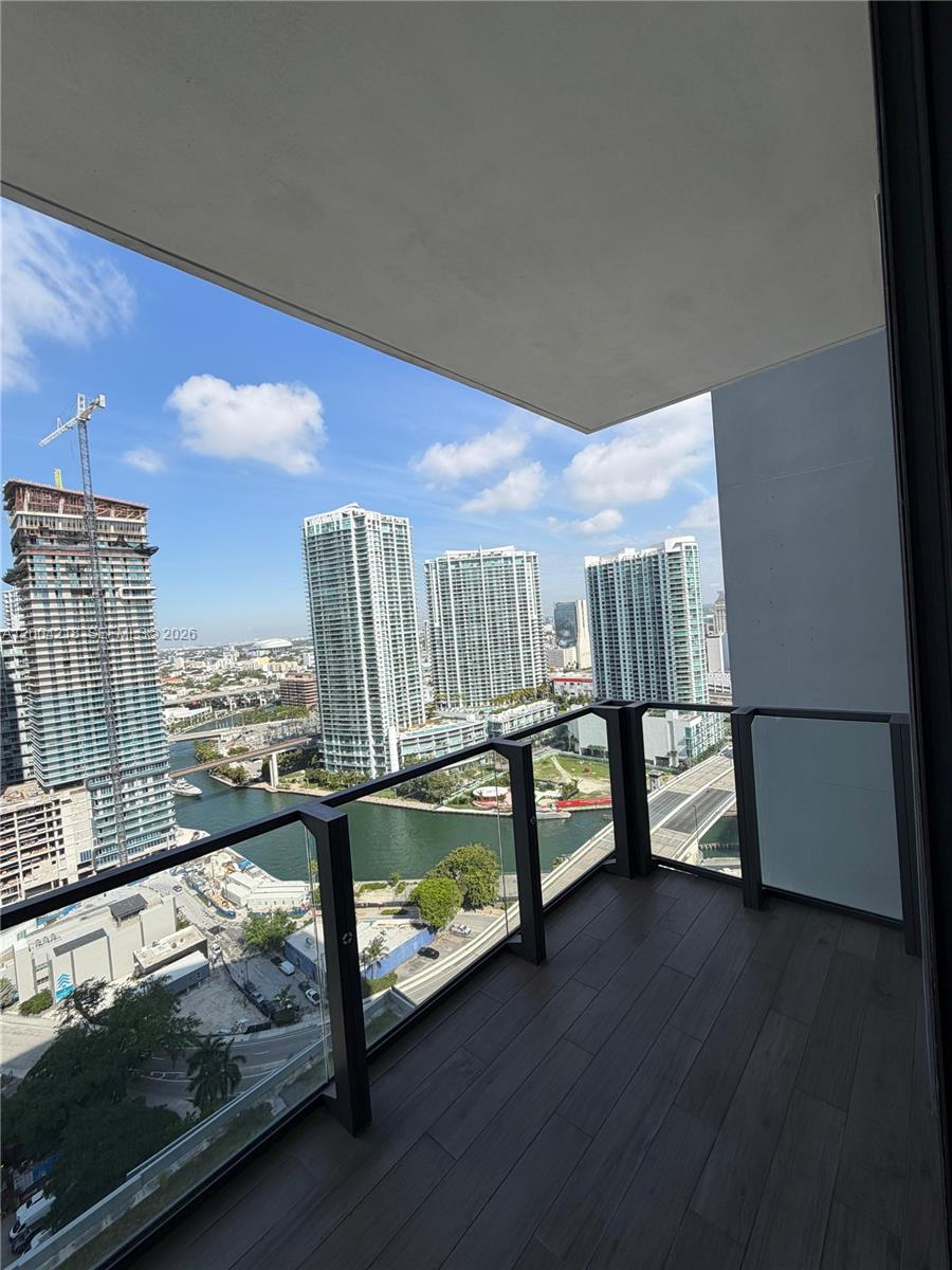 68 Southeast 6th Street, Unit 2506 Miami, FL 33131 - Photo 15 of 16 a room with wooden floor and furniture