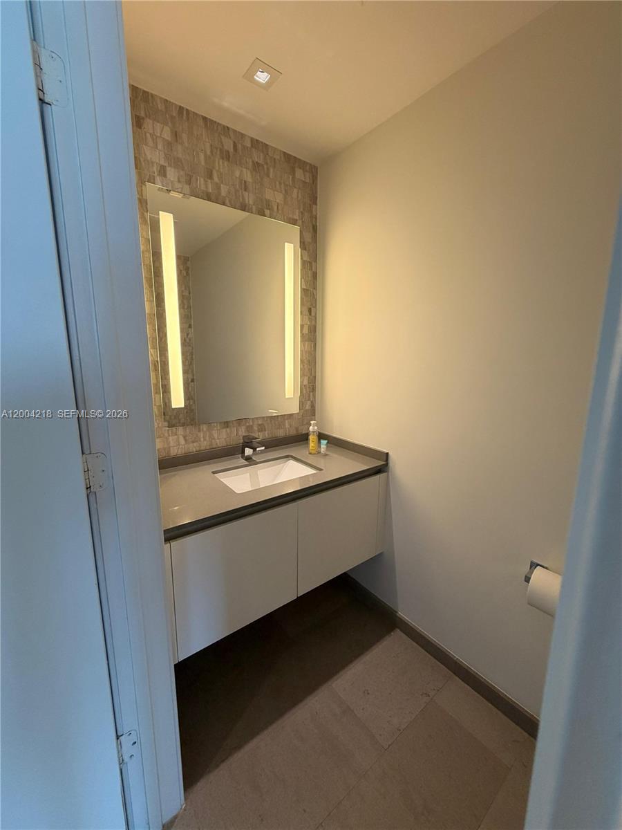 68 Southeast 6th Street, Unit 2506 Miami, FL 33131 - Photo 16 of 16 a bathroom with a sink and a mirror