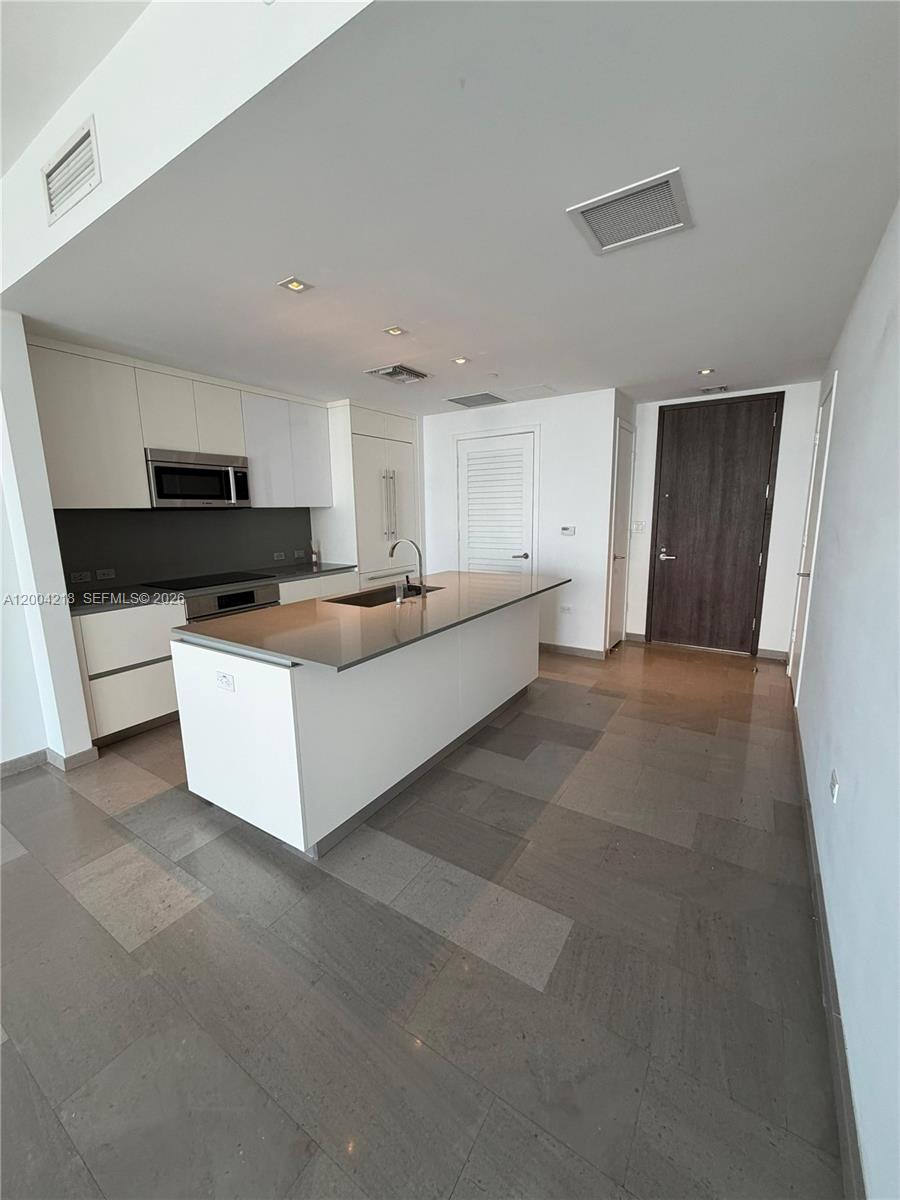 68 Southeast 6th Street, Unit 2506 Miami, FL 33131 - Photo 2 of 16 a large kitchen with a stove and a refrigerator