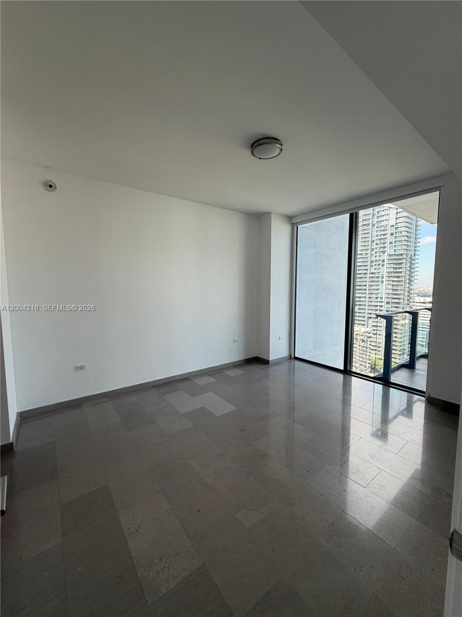 68 Southeast 6th Street, Unit 2506 Miami, FL 33131 - Photo 5 of 16 an empty room with windows and view