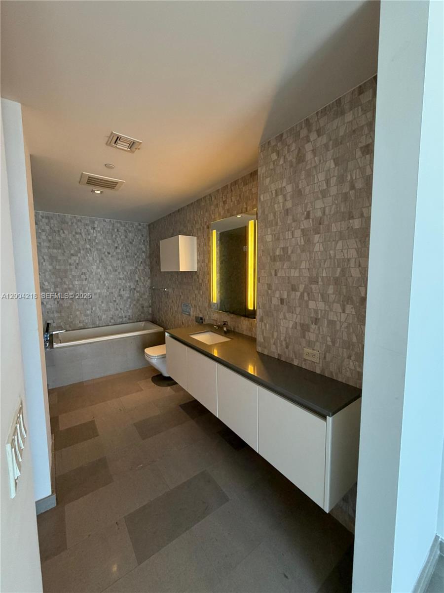 68 Southeast 6th Street, Unit 2506 Miami, FL 33131 - Photo 7 of 16 a bathroom with a double vanity sink and mirror
