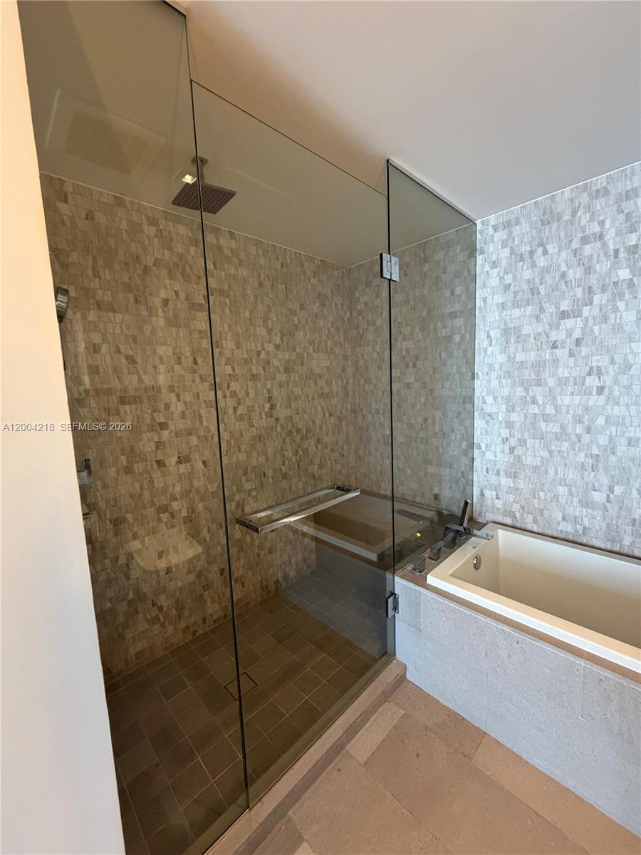 68 Southeast 6th Street, Unit 2506 Miami, FL 33131 - Photo 8 of 16 a bathroom with a bathtub and shower