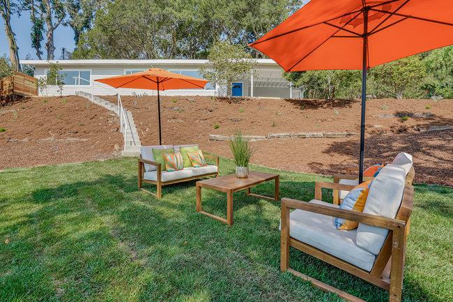 908 Holly Road Belmont, CA 94002 - Photo 43 of 50 an outdoor sitting area with furniture and umbrella