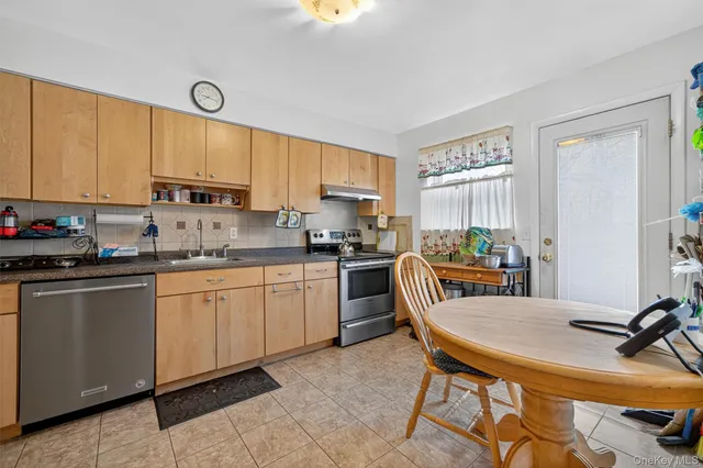 a kitchen with a table chairs sink and cabinets