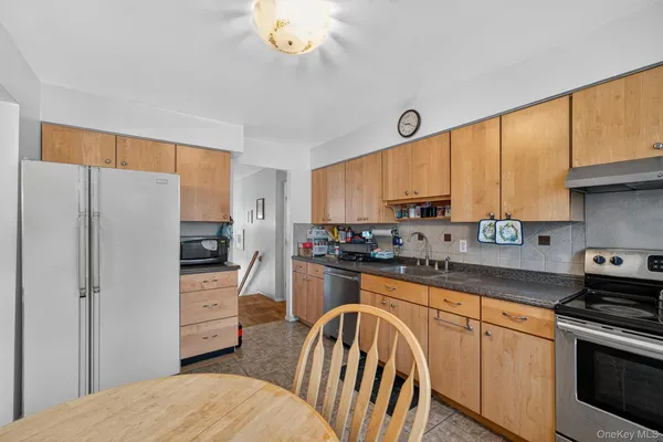 a kitchen with stainless steel appliances granite countertop a refrigerator stove microwave sink and cabinets