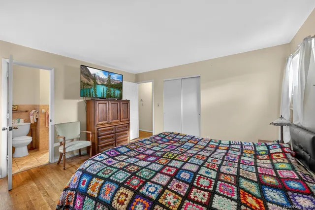 a bedroom with a bed and a tv on the dresser